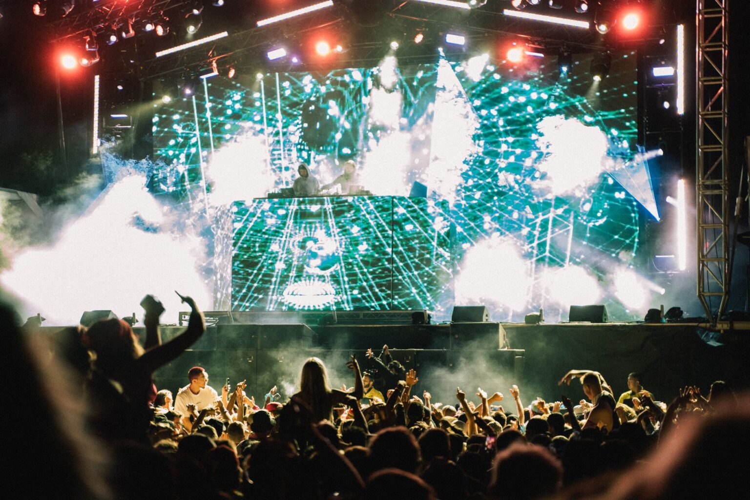 Tłum tłumu na festiwalu nowa muzyka przed dużą sceną z DJ-em i efektownymi wizualizacjami świetlnymi